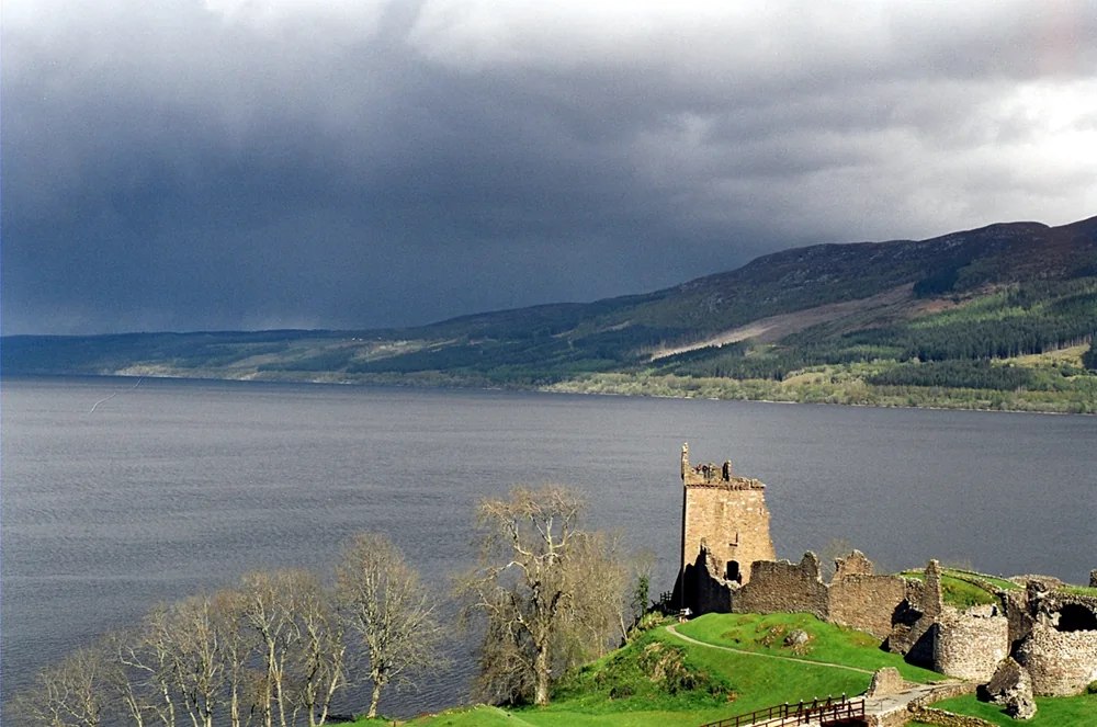 Loch Ness mit Urquhart Castle unter dunklem Himmel